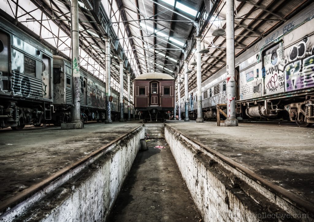 Looking down a service pit between rail roads at the Eveleigh Paint Shop, the sawtoothed roof visible above