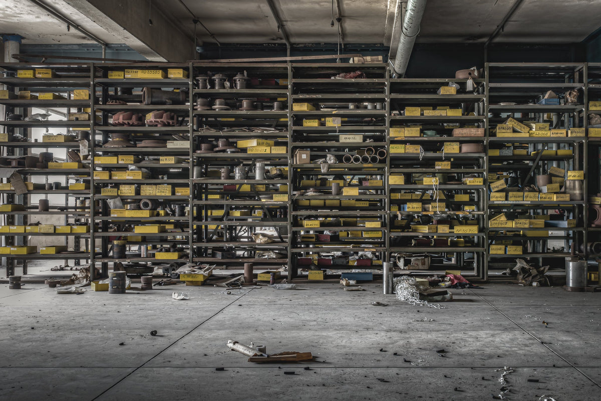 Workshop storage shelves at Wangi Power Station, stacked with yellow industrial tins and spare parts.