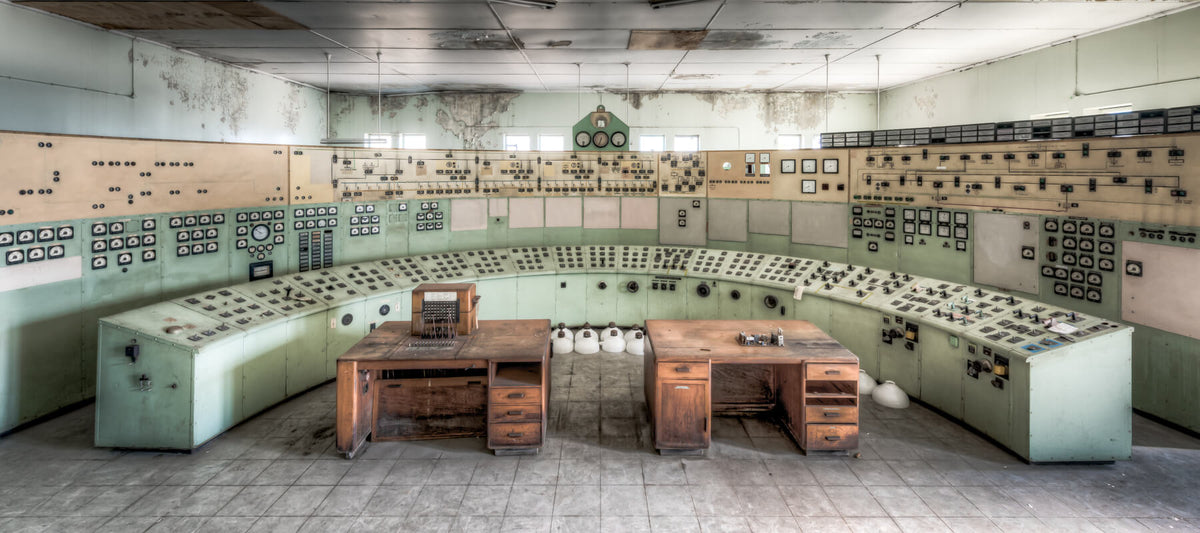 The control room at White Bay Power Station, a sweeping arc of mint green panels covered in dials, gauges, and switches, with two wooden control desks at the centre.