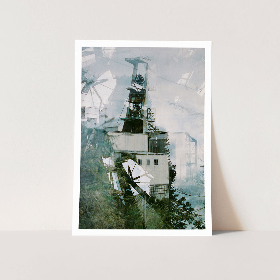 Multiple exposures stack the steel headframe and spoked winding wheels of Ikeshima Coal Mine above a rendered engine house, with blurred foliage across the foreground and a corrugated metal structure to the right.