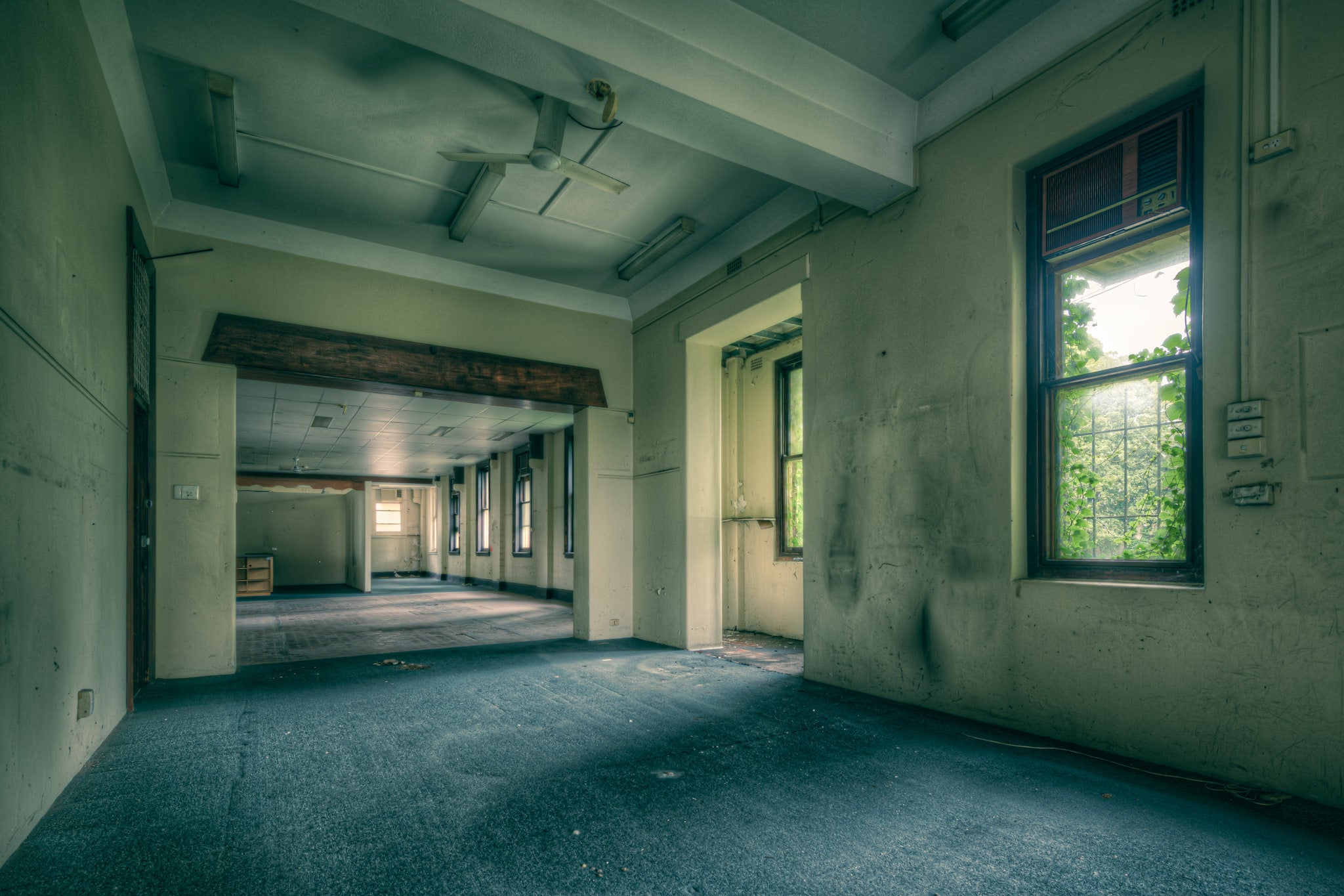 Top Floor at Lewisham Hospital, green carpet covers the floor of a large empty room on the upper storey.