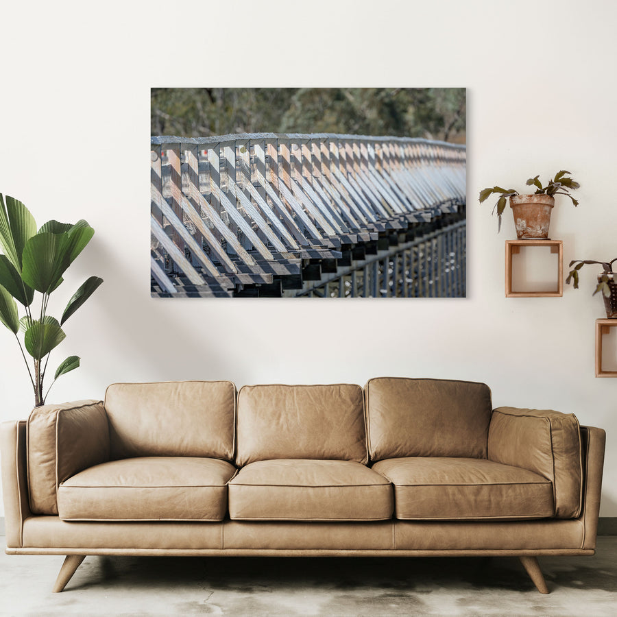 Close view along the weathered white-painted timber side railing of McKillops Bridge in the Deddick Valley, glass print displayed in situ on a wall.