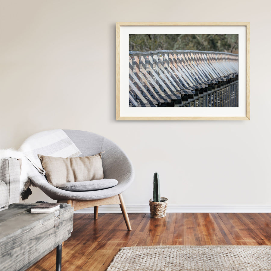 Close view along the weathered white-painted timber side railing of McKillops Bridge in the Deddick Valley, raw timber-framed print displayed in situ on a wall.