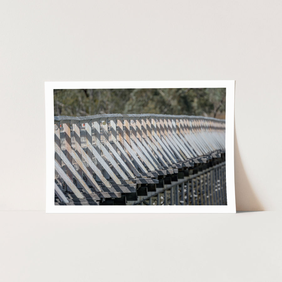 Close view along the weathered white-painted timber side railing of McKillops Bridge in the Deddick Valley, unframed print displayed in situ on a wall.