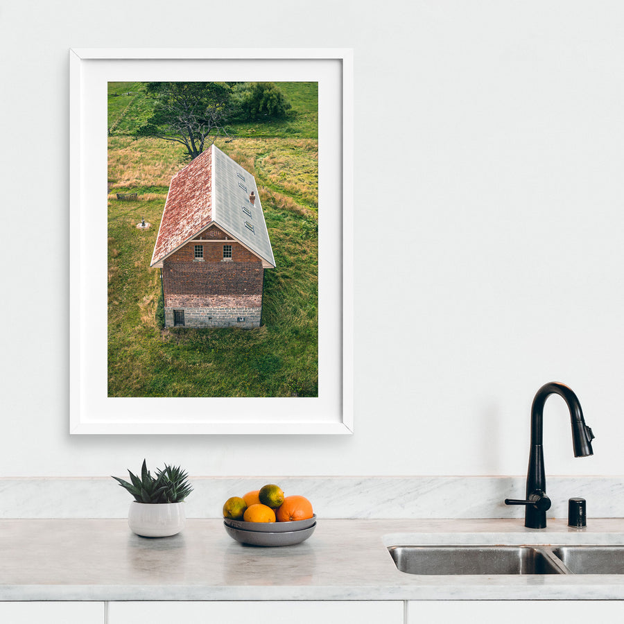 Pitched roof and brick gable at Jembaicumbene, copper and grey iron cladding with a brick chimney.