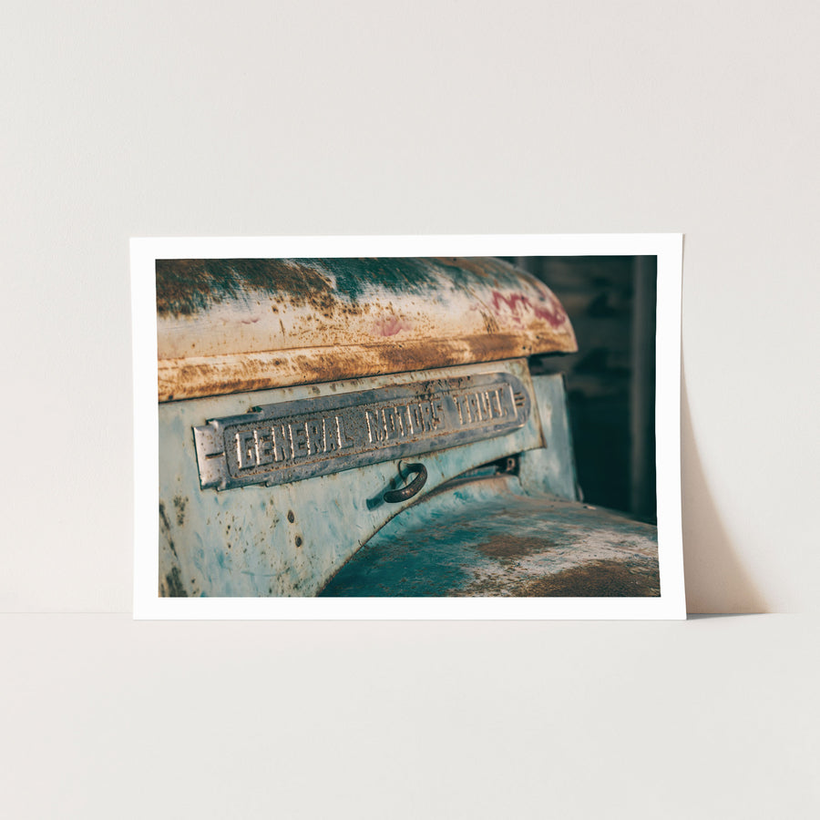 A rust-streaked General Motors Truck nameplate on a corroded faded blue body panel photographed at Jembaicumbene, New South Wales.
