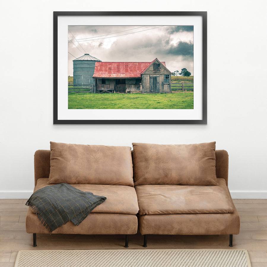 Timber stable at Braidwood, rusting red iron roof beside a tall grey grain silo.