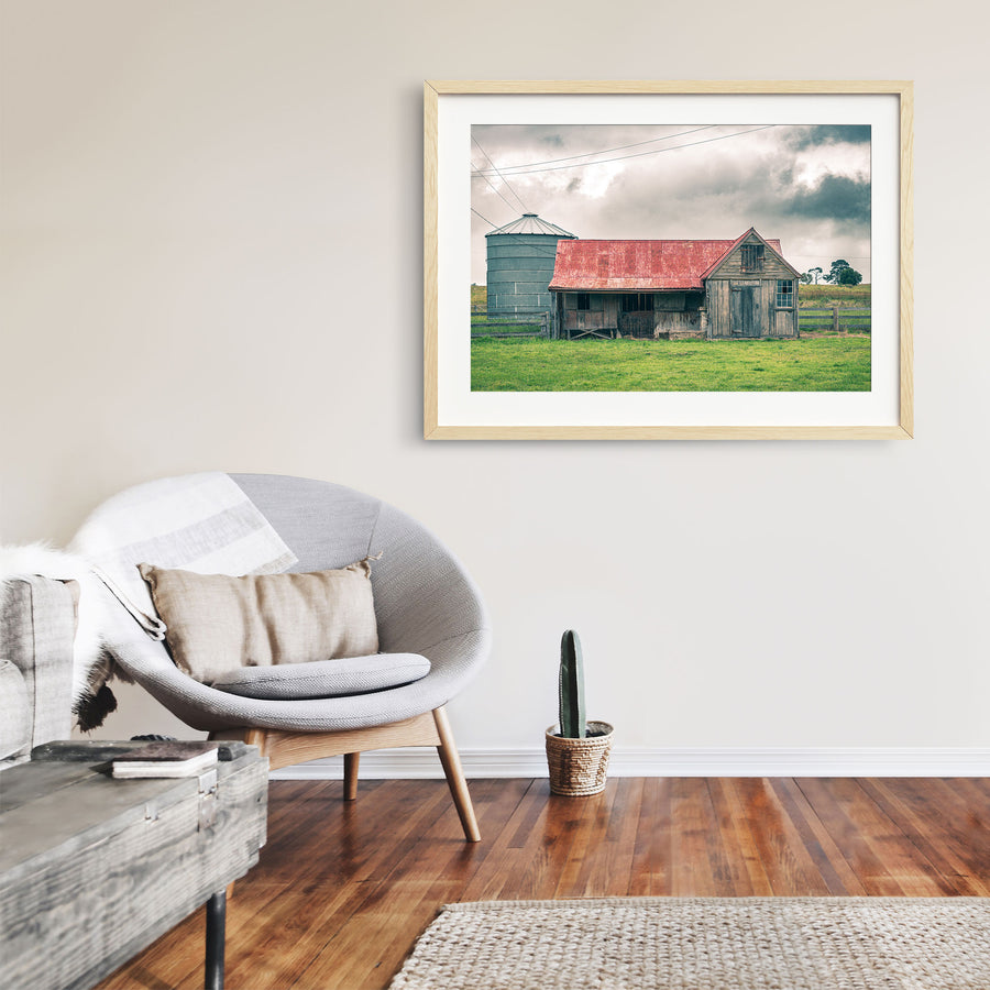 Timber stable at Braidwood, rusting red iron roof beside a tall grey grain silo.