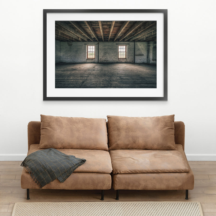 Upper room at Jembaicumbene grain store, two sash windows in a whitewashed brick wall under timber beams.