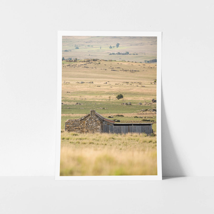 Dalgety Down The Range at A Place to Call Home, a small stone hut sitting alone on a grassy plain which extends well.