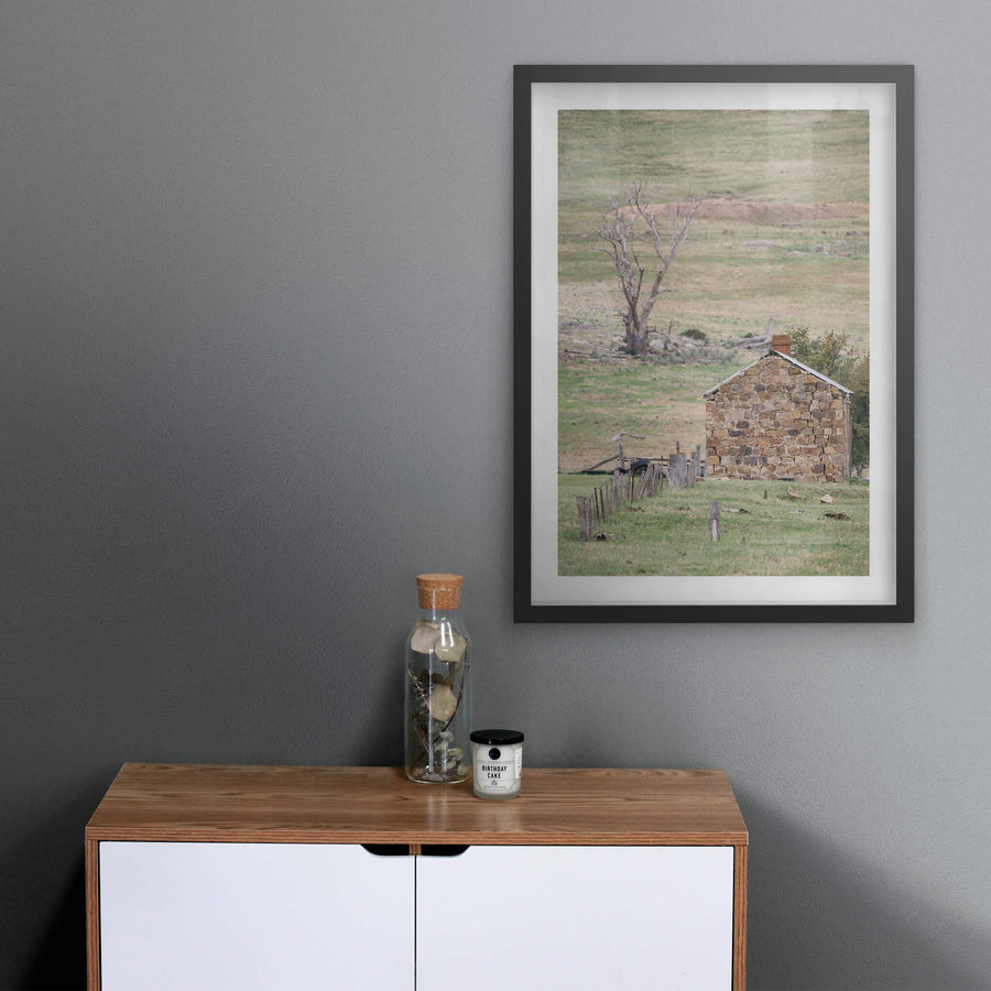 Jindabyne Hut at A Place to Call Home, a stone cottage sits low in open pastoral land near Jindabyne.