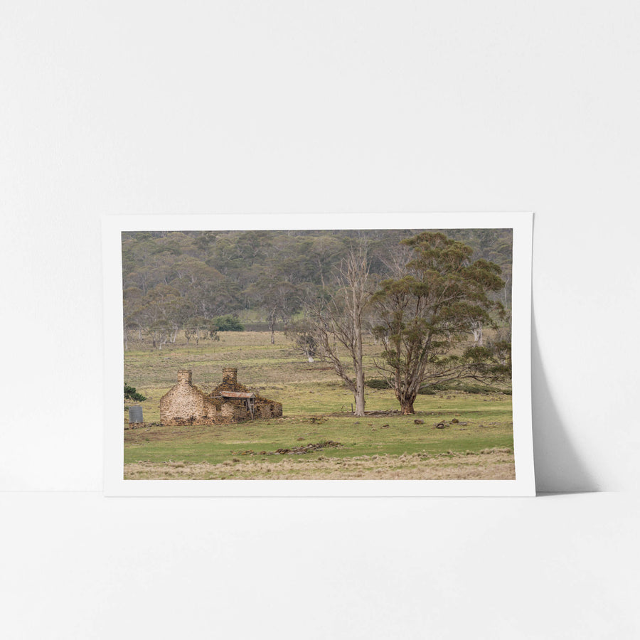 Stone Home Ruins at A Place to Call Home, a stone cottage stands roofless in green pastoral land, its thick walls still.