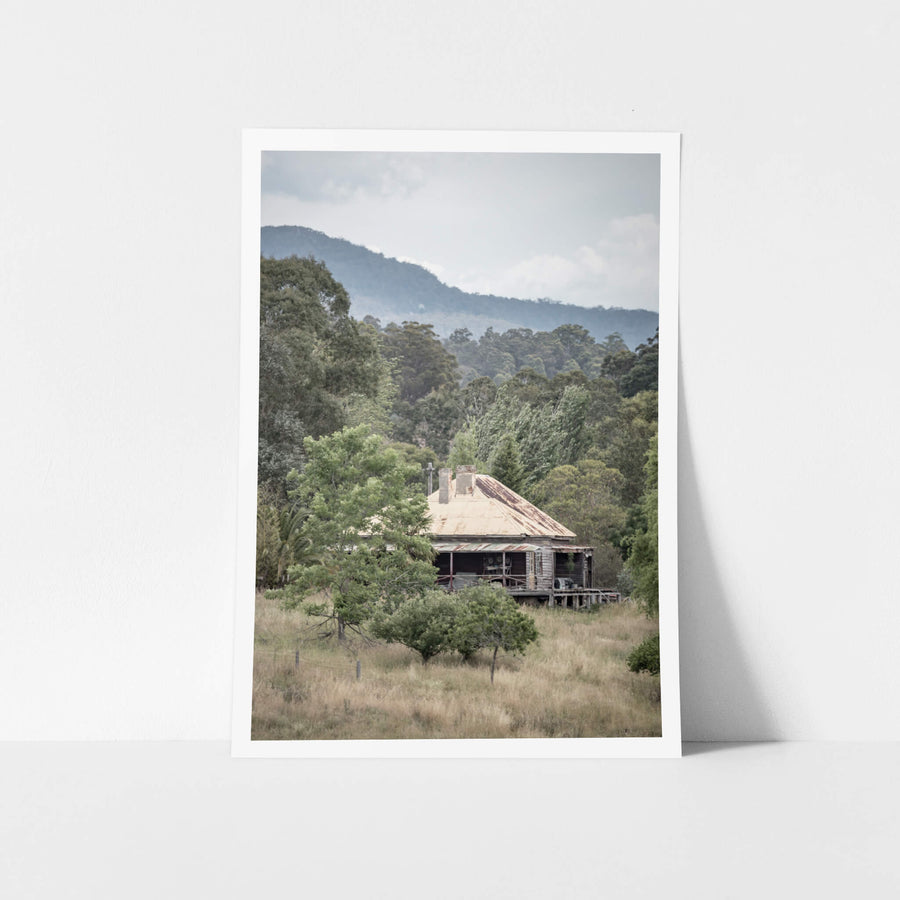 Wyndam Home at A Place to Call Home, a weatherboard homestead sits low in dry grass, its hipped roof a patchwork of rust.