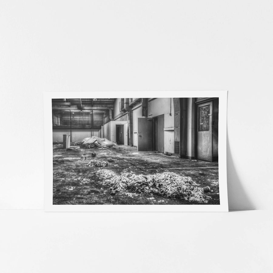 Canteen at ATL Building, a heap of crumpled fabric or paper sits in the centre of a bare concrete floor.