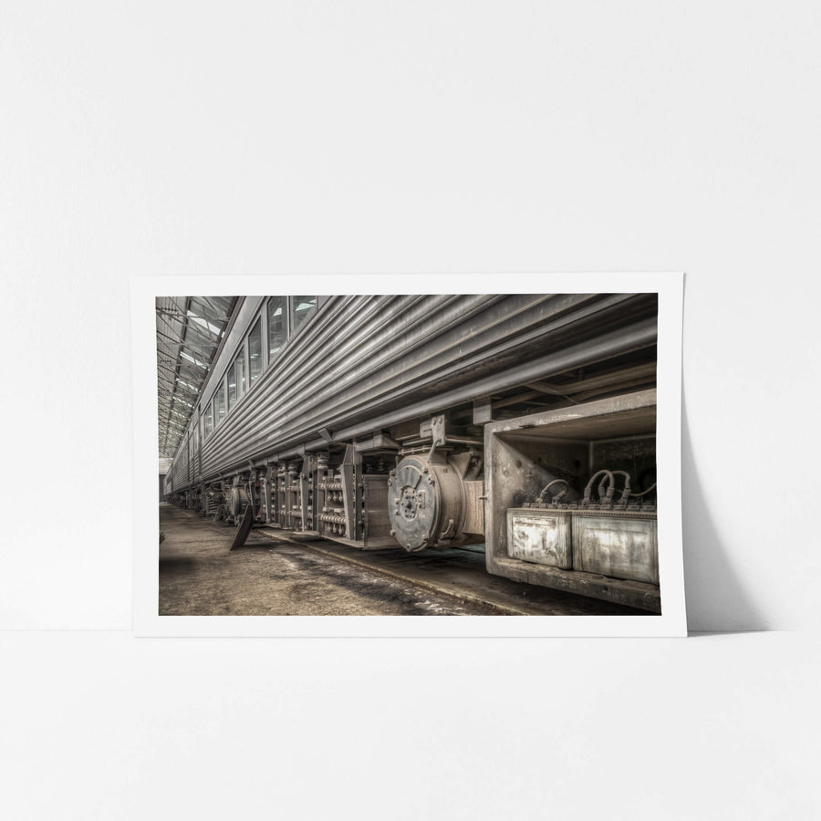 Batteries at Eveleigh Paint Shop, the underside of a stainless steel interurban carriage fills the frame.