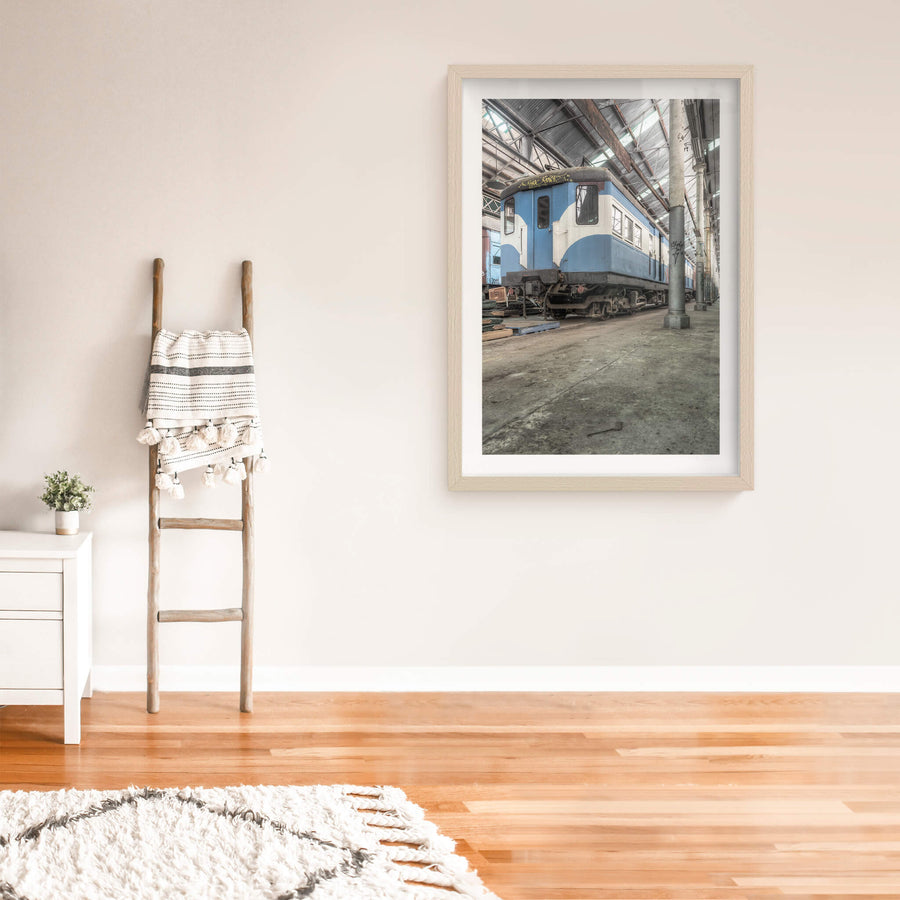 Phillip Shirley at Eveleigh Paint Shop, a blue and white railway carriage sits on bare concrete inside the Eveleigh Paint Shop.