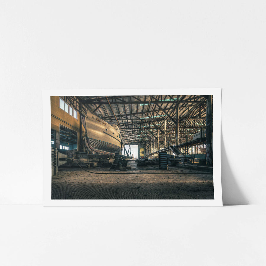 Beneath the Boat at Halvorsens Boat Yard, a timber-hulled vessel sits on steel cradle blocks inside the main shed.
