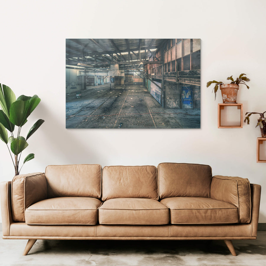 Mezzanine at Halvorsens Boat Yard, steel trusses span the full width of the shed, bolted to rust-streaked columns.