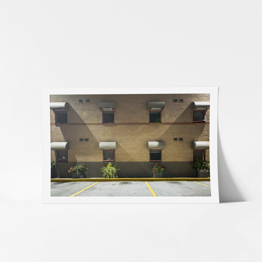 Sleep Express at Hotel Motel 101, two storeys of blonde brick face an empty car park.