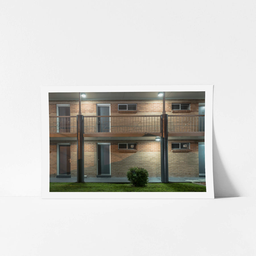 The Oaks Motel at Hotel Motel 101, two storeys of brown brick face the car park under fluorescent security lights.