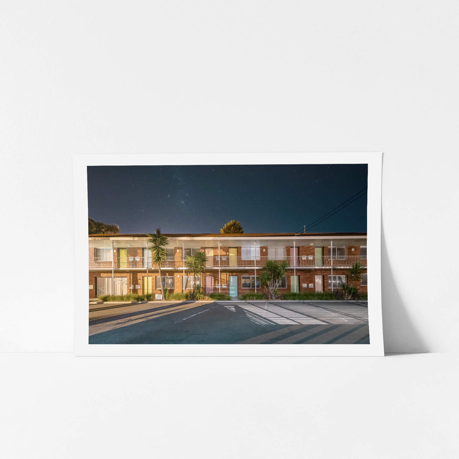 Thirroul Beach Motel, Thirroul at Hotel Motel 101, a red brick motel with pastel coloured doors under a starlit sky.