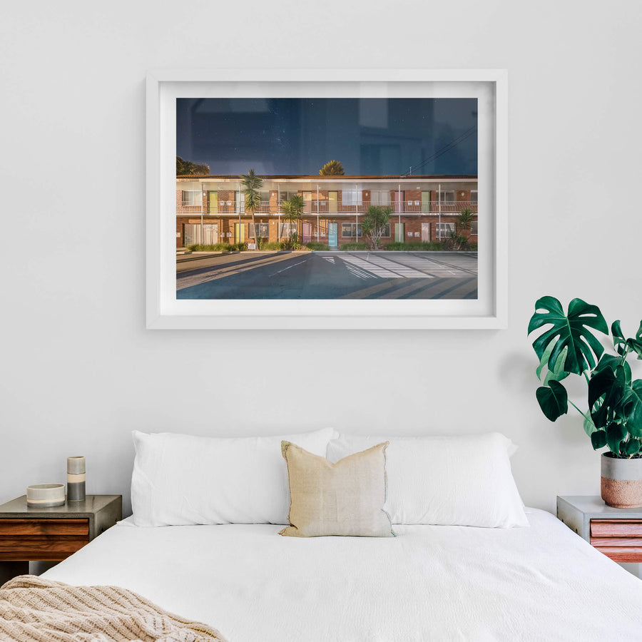 Thirroul Beach Motel, Thirroul at Hotel Motel 101, a red brick motel with pastel coloured doors under a starlit sky.