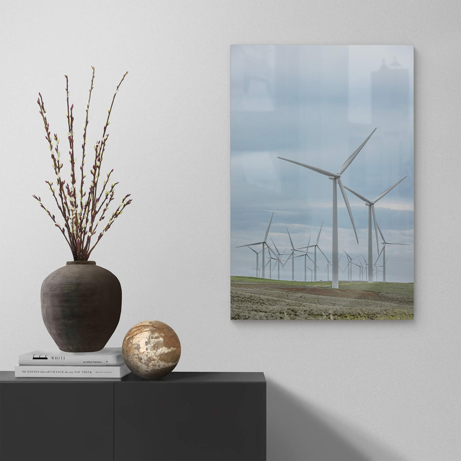 Cluster at Landscapes, white steel towers rise from low, green-brown pastureland under a flat grey sky.