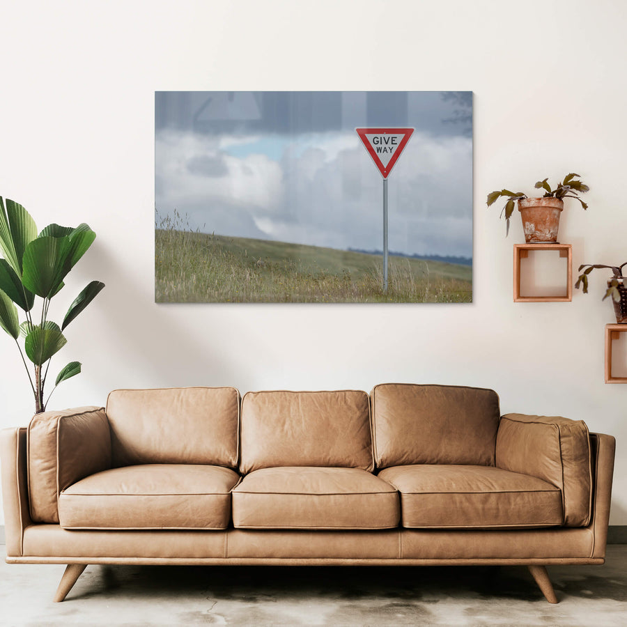 Give Way at Landscapes, a galvanised steel post rises from long grass on a bare hillside.