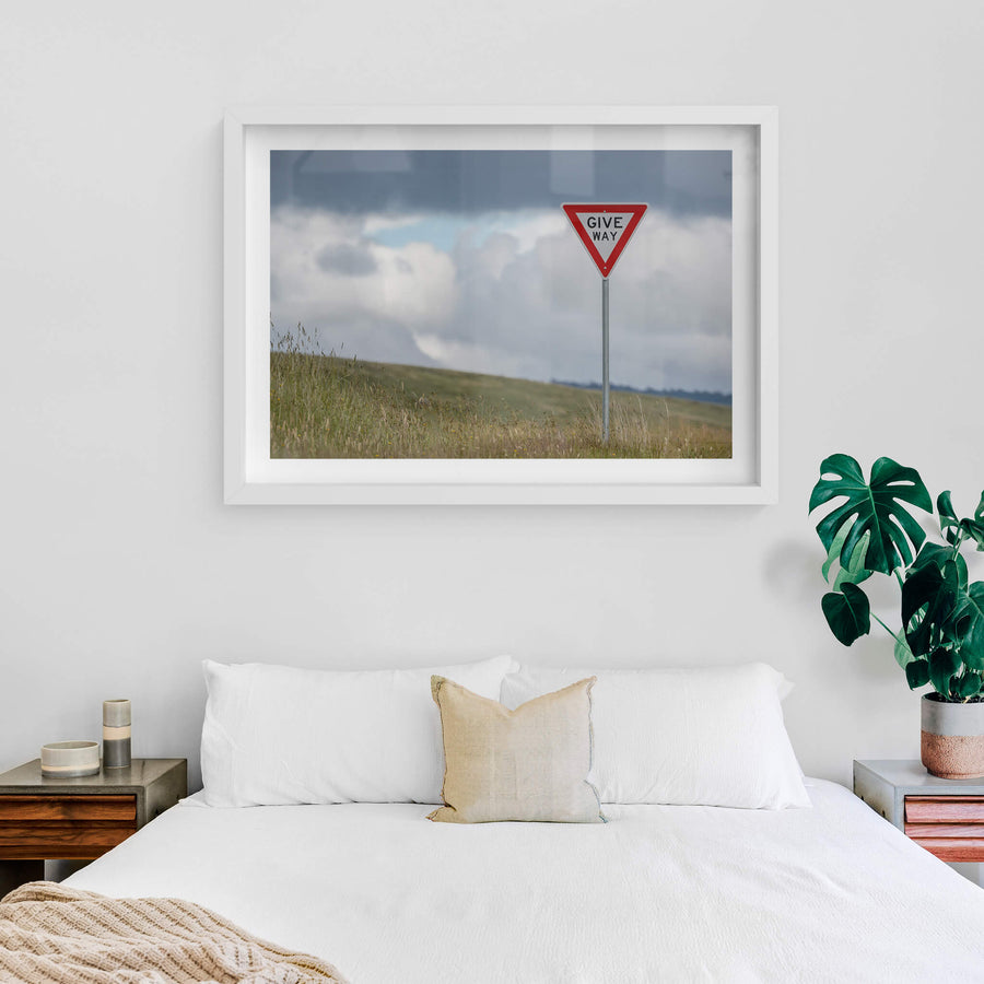 Give Way at Landscapes, a galvanised steel post rises from long grass on a bare hillside.