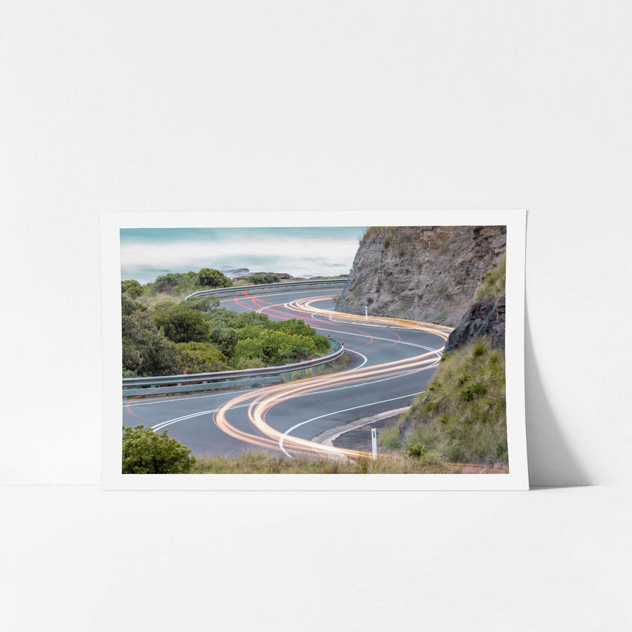 Meander at Landscapes, the Great Ocean Road winds through a cutting in the coastal rock face, the asphalt banking hard.