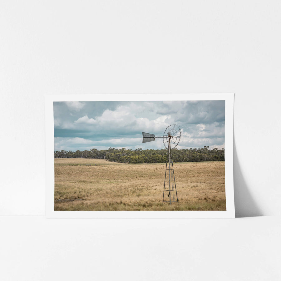 Snowy Mountains Windmill at Landscapes, a lone windmill in a paddock on a cloudy afternoon.