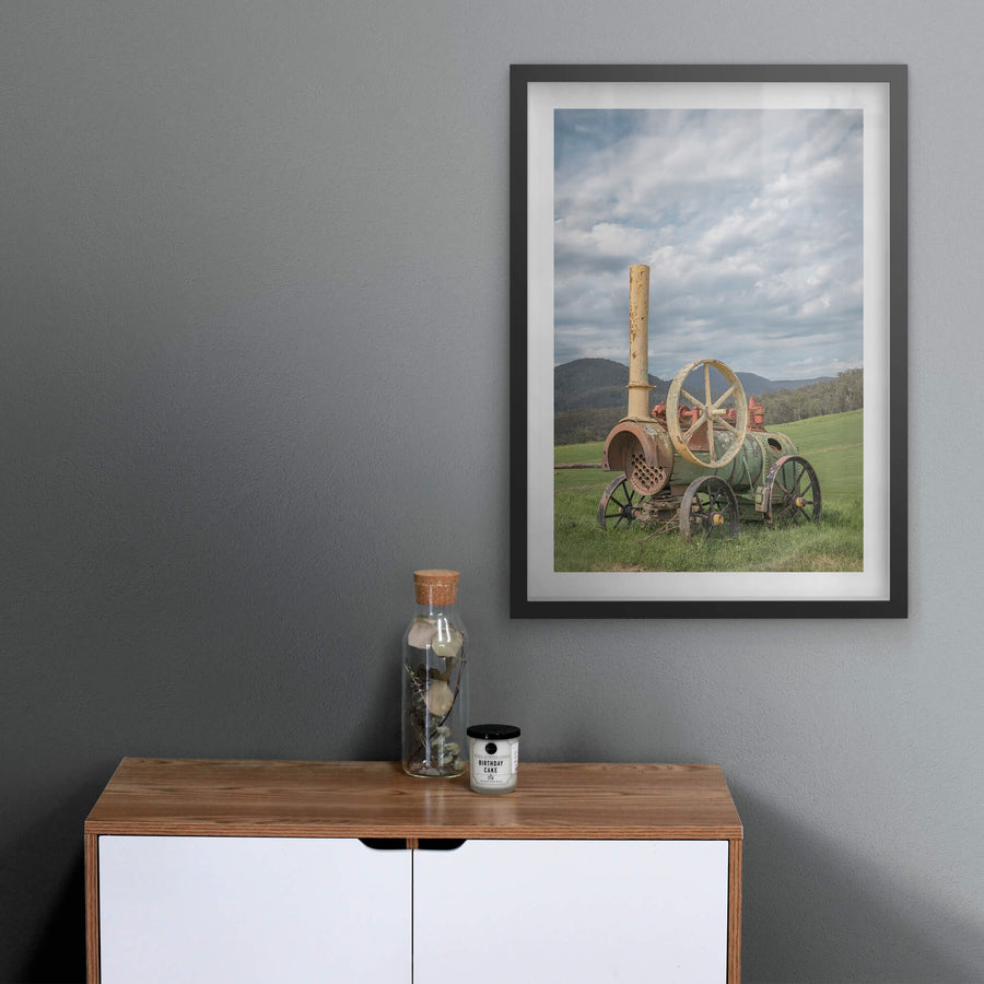 Steam Machine at Landscapes, a portable steam engine sits in open pasture, its iron wheels sunk into thick green grass.