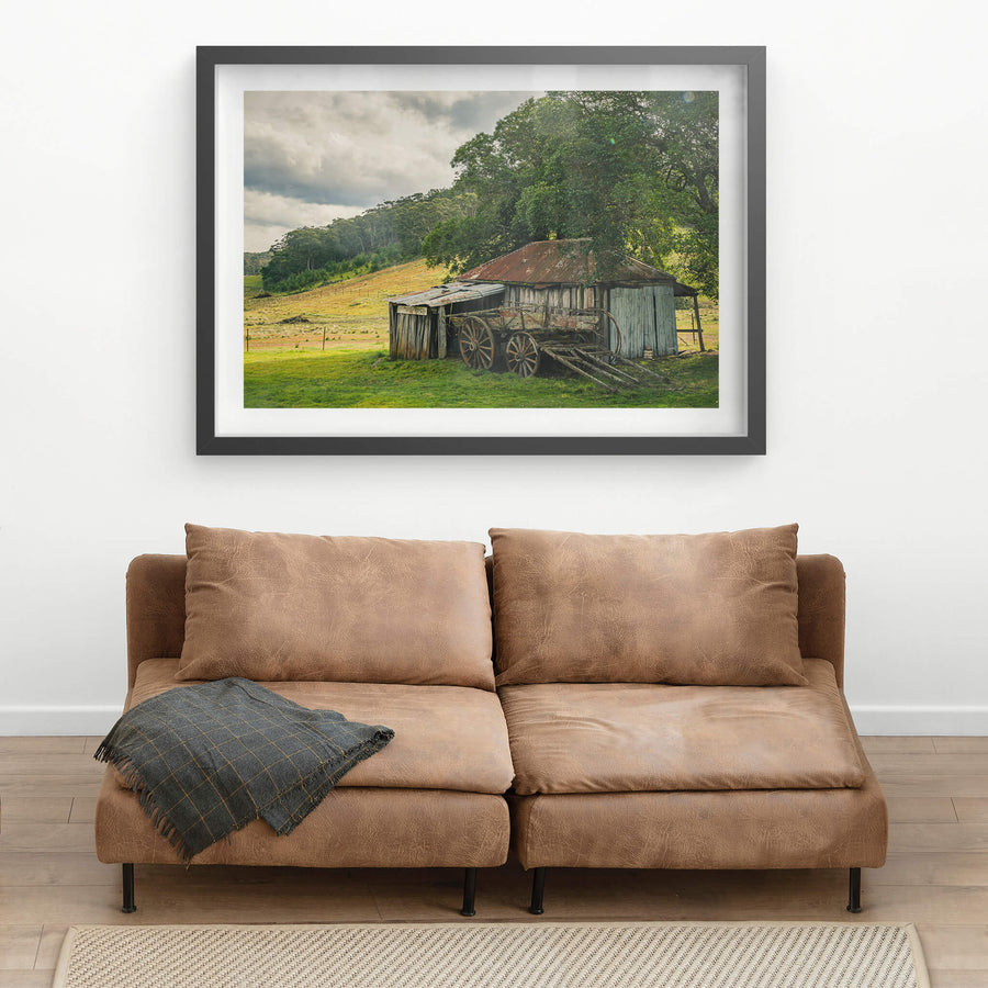 Hills at Leichhardt House, a weathered timber shed sits low against green pasture, its corrugated iron roof streaked deep.