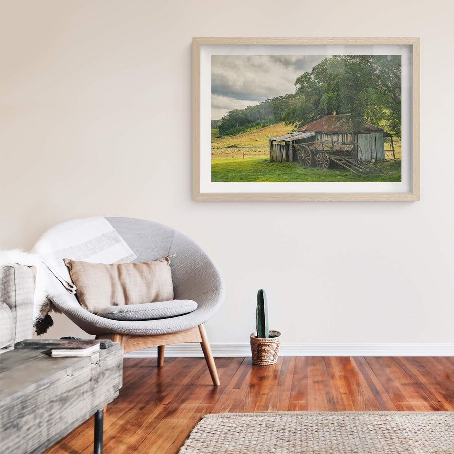 Hills at Leichhardt House, a weathered timber shed sits low against green pasture, its corrugated iron roof streaked deep.