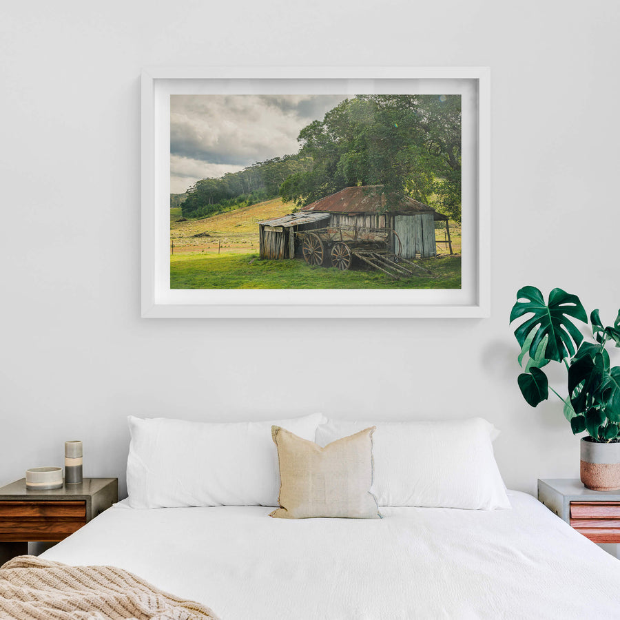 Hills at Leichhardt House, a weathered timber shed sits low against green pasture, its corrugated iron roof streaked deep.
