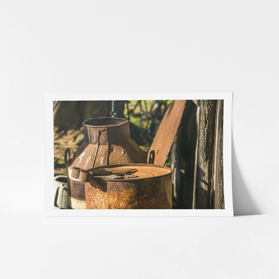 Rust at Leichhardt House, two steel milk cans sit against a weathered timber wall.