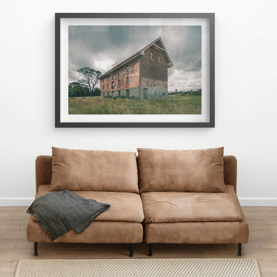 End of the Mill at Mill Pond Farm, a two-storey brick and bluestone building stands alone in open grassland.