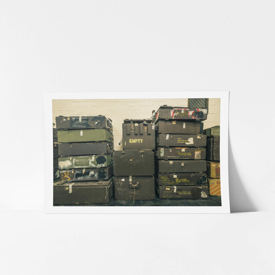 Crates at Newington Armory, military munitions crates stacked three columns high against a whitewashed brick wall.
