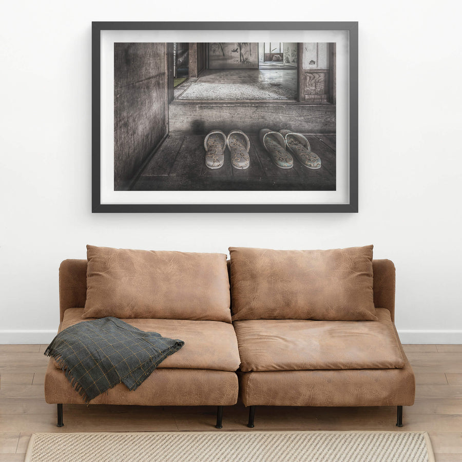 Genkan at Nichitsu Mining Village, two pairs of slippers sit on the worn timber floor of a genkan, their floral fabric.