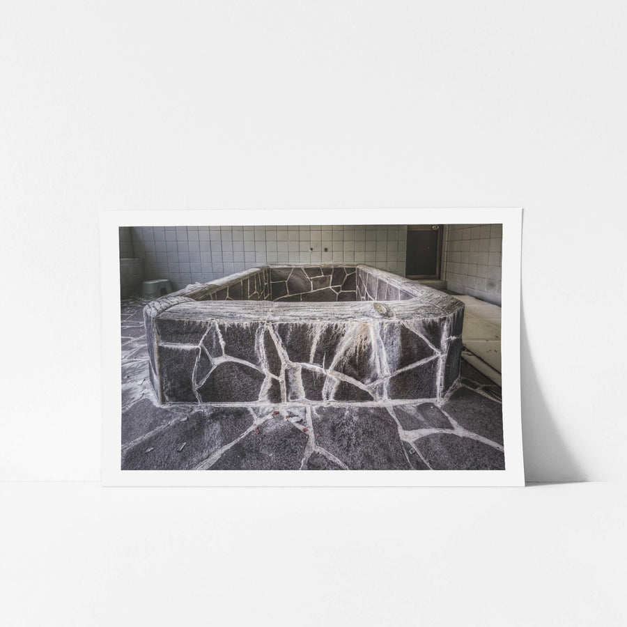 Public Bath at Nichitsu Mining Village, a hexagonal stone bath sits dry and empty in a tiled room.