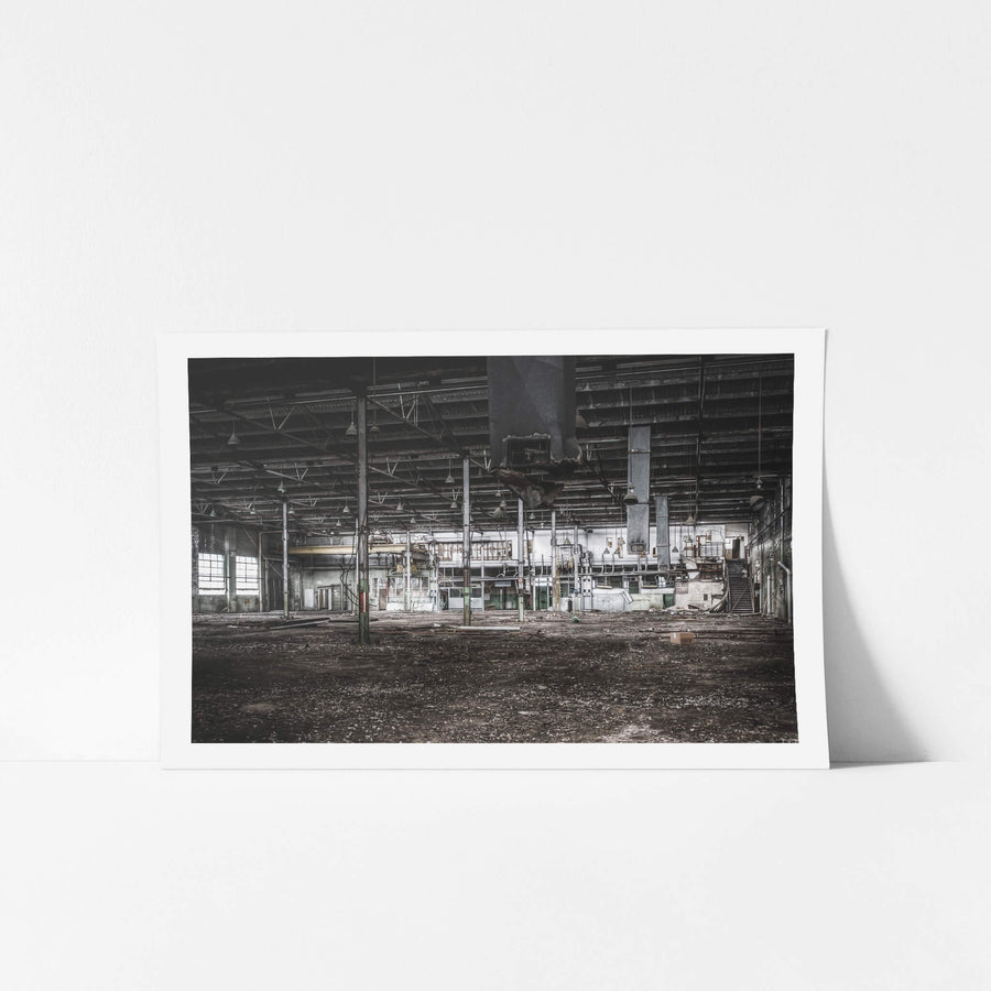 Factory Floor at O-I Glass, a vast industrial floor stretches out beneath a steel-trussed roof.