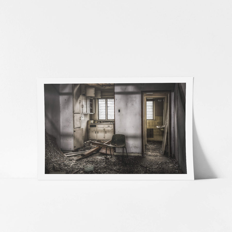 Living Quarters at O-I Glass, a moulded fibreglass chair sits in the centre of a wrecked kitchenette.
