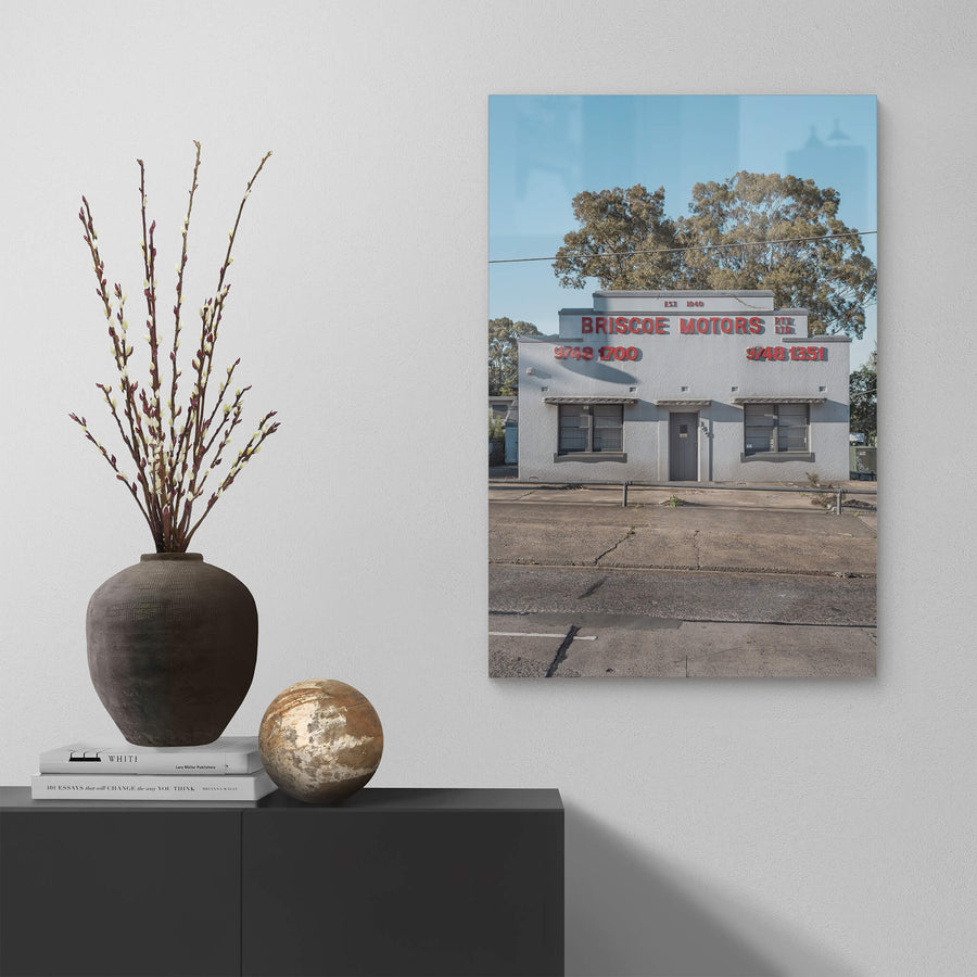 Briscoe Motors at Parramatta Road, a white rendered Art Deco façade sits square to the street.