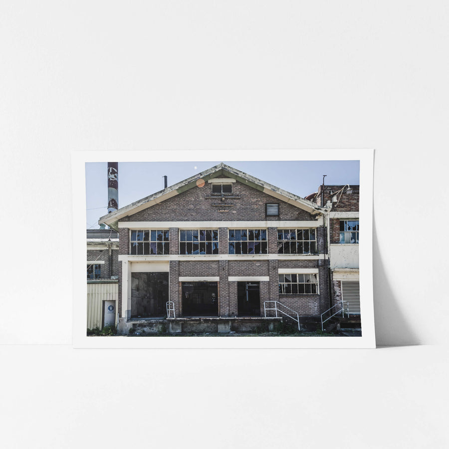 Boiler House Facade at Peters Ice Cream Factory, two storeys of brown brick and concrete banding, squared off under a gabled roofline.