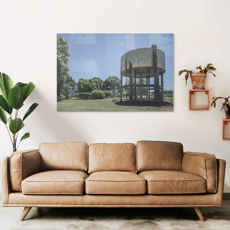 Front Lawn at Peters Ice Cream Factory, a cylindrical steel water tank sits raised on six legs above a mowed front lawn.