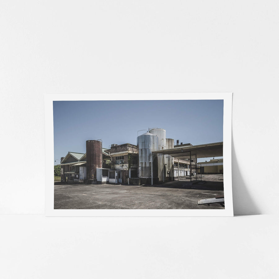 North Eastern Corner at Peters Ice Cream Factory, stainless steel silos and a rusted cylindrical tank rise above the concrete yard at the north-eastern corner of the Peters Ice Cream Factory in Warwick Farm.