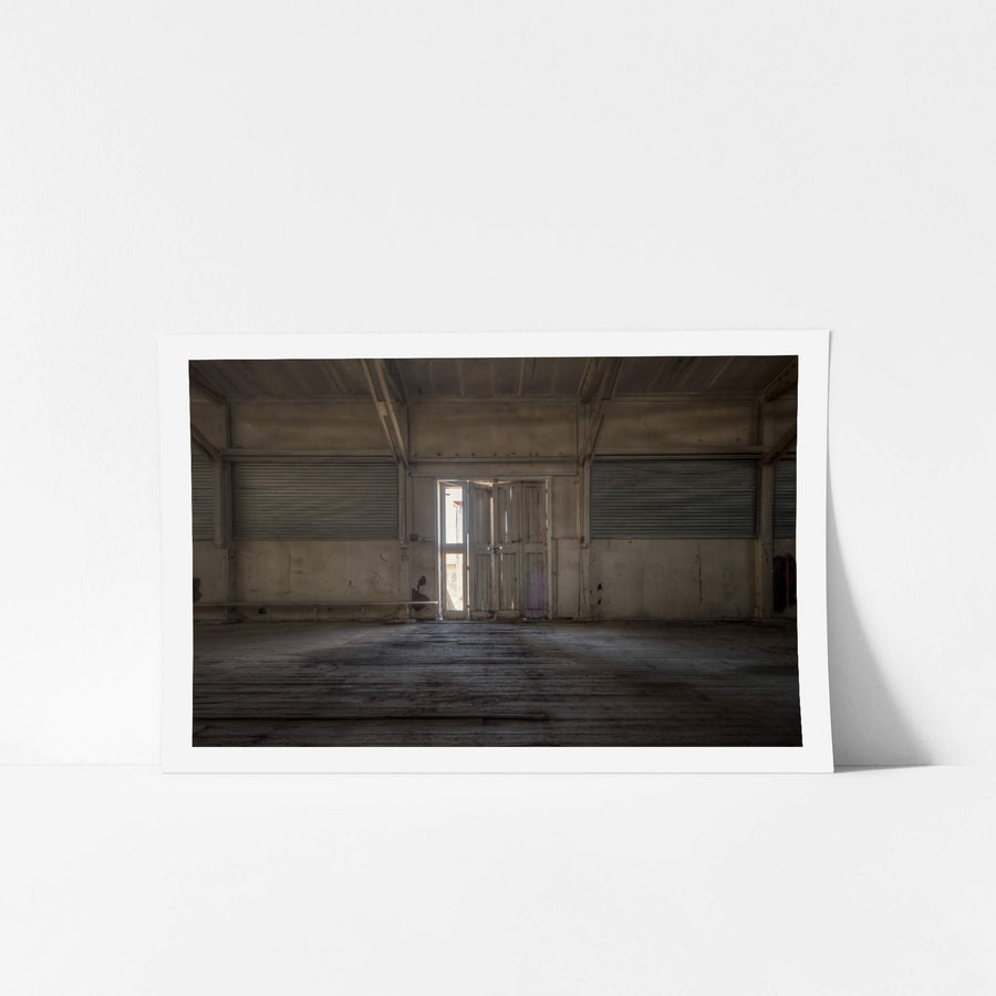 Annex Door at Portland Cement Works, a pair of timber doors stands half-open at the centre of a concrete wall.