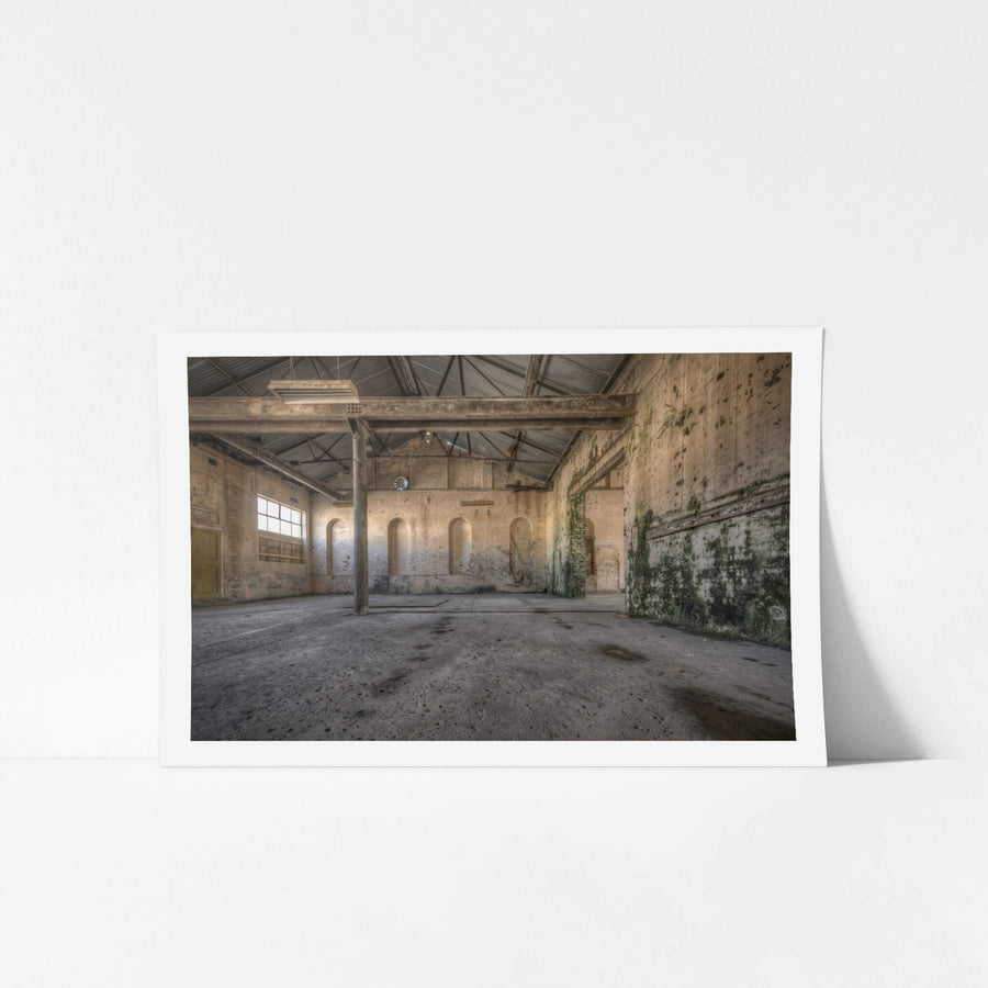 Green Wall at Portland Cement Works, a single steel column rises from a stained concrete floor, supporting iron roof.