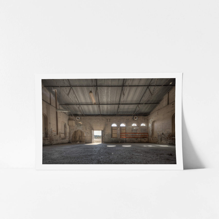 Opening at Portland Cement Works, pale brick walls rise to a corrugated iron roof inside one of the Portland Cement Works.