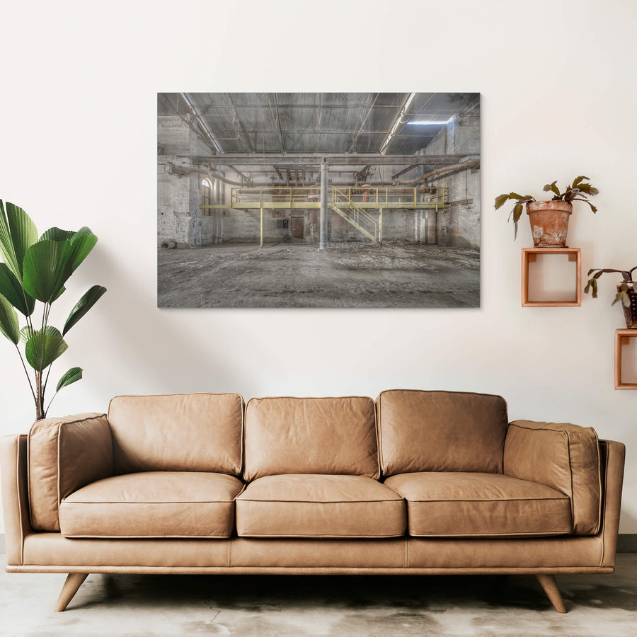 Pipework at Portland Cement Works, a yellow steel mezzanine spans the width of the building, its walkway and staircase.